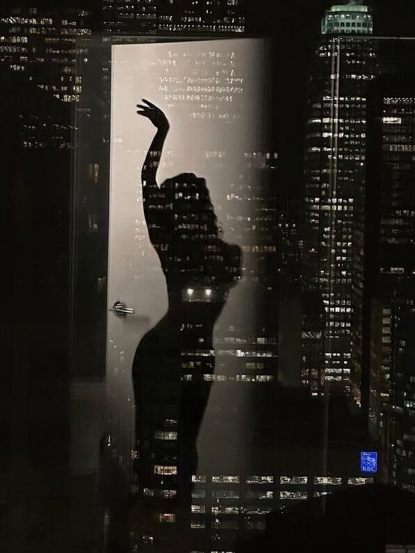 Elegant female silhouette reflected in a Madrid window - discreet high-end escort experience